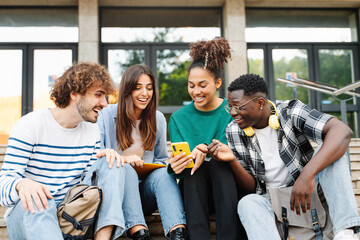 Group young friends sitting together using mobile phones to share content on social media