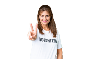 Middle age volunteer woman over isolated background smiling and showing victory sign