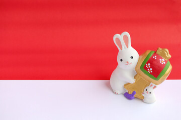 Figure of white rabbit on red background with blank space for a greeting text. Chinese new year 2023 of the rabbit concept.