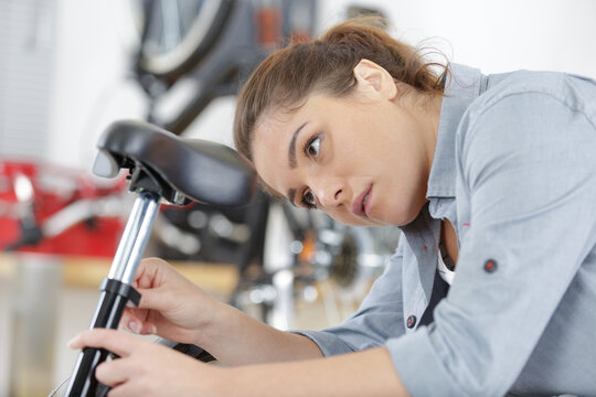 female bicycle mechanic repairing a bike saddle