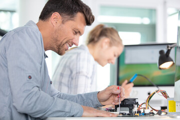 technicians working on robotic electronical parts