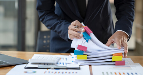 Asian businessman working in the office I'm dealing with the datasheet. financial performance...