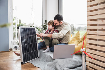 Father and son looking at solar panel
