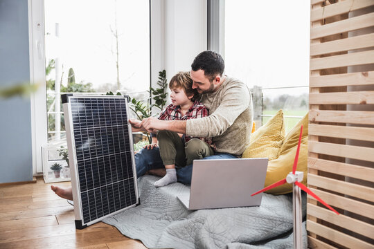 Father and son looking at solar panel