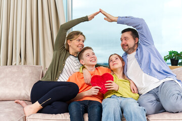 Happy family with kids sit on sofa in living room have fun using laptop together, smiling parents rest on couch enjoy weekend with childrens laugh watch video on computer at home