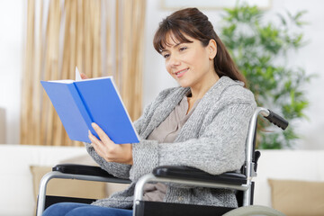 young disabled woman in wheelchair reads book