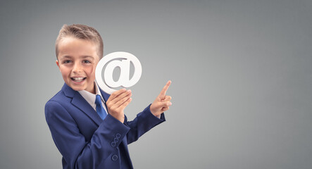Young executive businessman boy with email at symbol pointing to copy space background