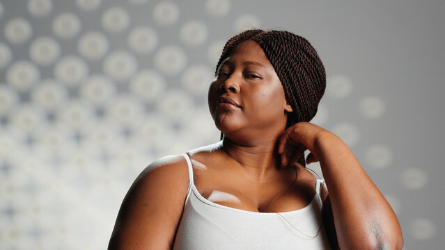 Smiling girl with radiant appearance promoting self love, creating new skincare ad campaign and posing with confidence. Beautiful positive woman expressing self acceptance in studio.