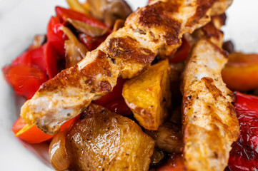 Pork souvlaki on baked vegetable.