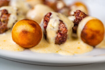 Baked meatball from beef, croquette in lemon sauce on white plate.