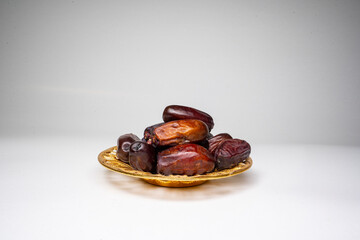 photo a small bowl of dates next to a handful on white background. high quality photo