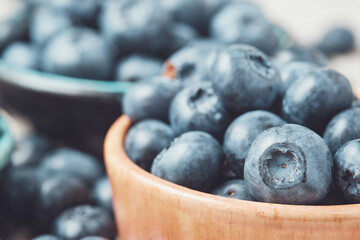 Three ceramic bowls with blueberries and berries scattered around.