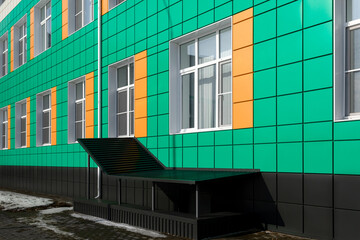 entrance group with flight of stairs and visor against background of green aluminum ventilated...