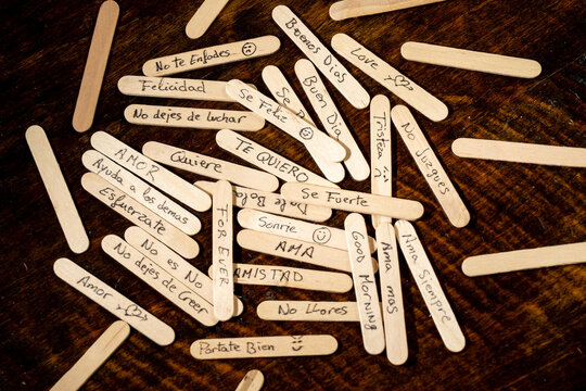 palitos de polo de madera con mensajes escritos a mano con boligrafo, condepto mensajes de la sociedad, tristeza, malos tratos, alegria, enfado, amor