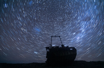 Star trail behind a shipwreck in the coast of patagonia