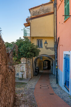Centro storico di Sanremo, in provincia di Imperia. Piccola strada acciottolata ed edifici residenziali colorati e vista sul porto. Liguria, Italia.