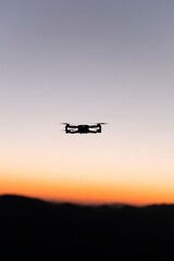 Fototapeta na wymiar Drone flying with mountains in the background during sunrise