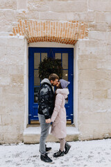 Fototapeta na wymiar couple in love is kissing in snowy winter town