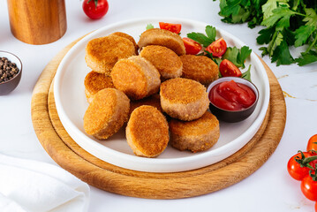 chicken nuggets in a plate on a light background, tomato sauce, 