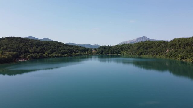 Immerse in the serenity of a tranquil lake, surrounded by lush greenery.  Still waters of the lake reflect the beauty of the surrounding landscape, creating a peaceful and picturesque scene | 4K