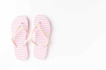 Overhead shot of pink flip flops on white background with copyspace