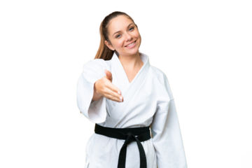 Young blonde woman doing karate over isolated chroma key background shaking hands for closing a good deal