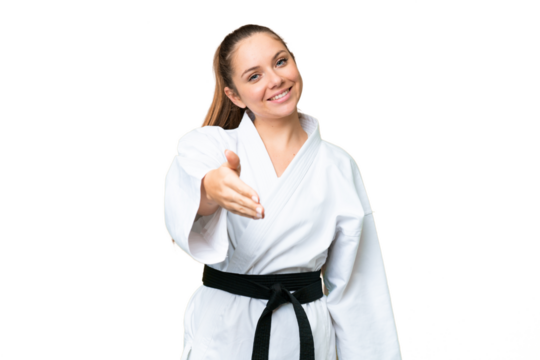 Young blonde woman doing karate over isolated chroma key background shaking hands for closing a good deal