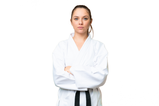 Young blonde woman over isolated chroma key background doing karate keeping the arms crossed