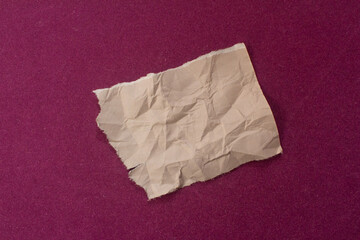 Obraz premium Crumpled paper on purple background. Ripped paper piece.