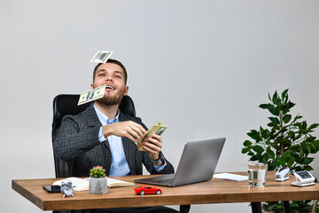 young bearded businessman working on laptop and throwing money