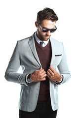 A trendy attractive young business magnet posing in a business suit with his trendy shades isolated...
