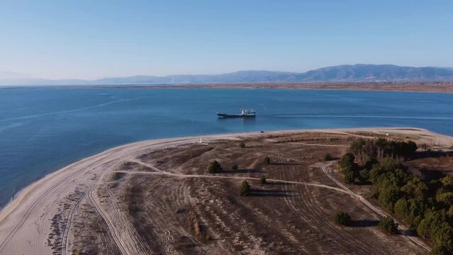 Aerial approaching ferry boat living port and beautiful sandy beach.