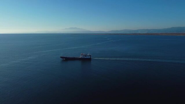 Drone following ferry boat travelling in the ocean on a clear sunny day. Greece