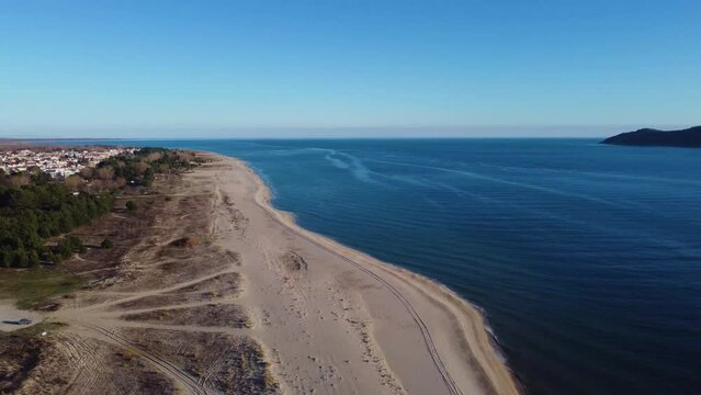 Aerial pull back over vast beach on sunny day. Keramoti, Greece.