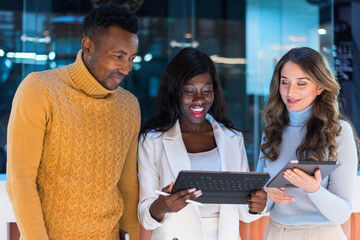 Multiracial group of people in an office discussing business using tablets