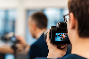 Professional photographer shooting another photographer in an office using a camera