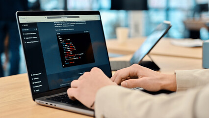 Close view of a software developer generating code in an AI chat by giving a request