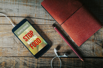 Stop wasting food app design on a mobile phone screen placed on a work desk.