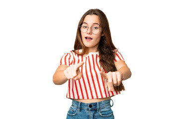 Teenager girl over isolated chroma key background surprised and pointing front