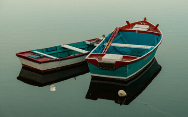 Small wooden boats on the water with reflections. High quality photo