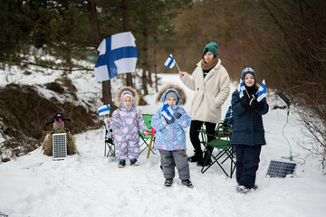 Finnish mother and children with Finland flags on a nice winter day. Nordic Scandinavian people.