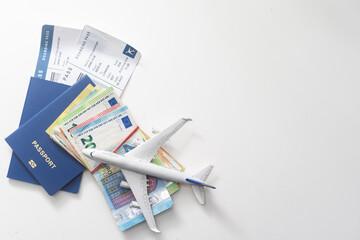 a miniature airplane , a passport case and euro money banknotes. selective focus. Travel concept