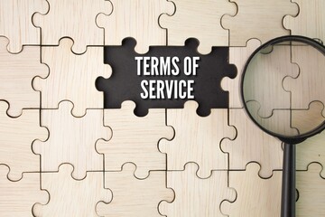 wooden puzzle and magnifying glass with the word term of services
