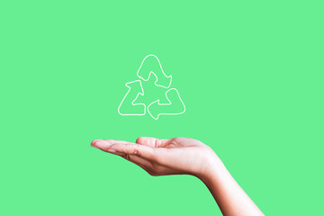 woman holding icon recycle on green background