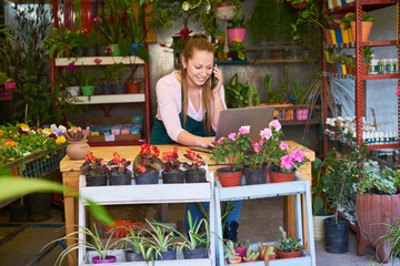 Florist in the flower shop talking on her mobile phone