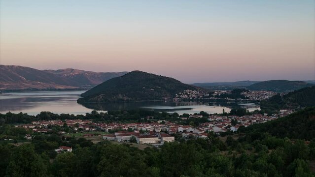 Day to night time lapse. A summer view to Orestiada lake and town of Kastoria in Greece. Fantastic view to Kastoria city and Orestiada lake during quiet summer evening