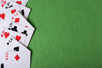 Playing cards on a green background with space for text