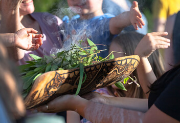 Australian Aboriginal smoking ceremony, human hands are touching the smoke of burning eucalyptus...