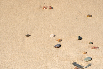 Fototapeta na wymiar A close-up of the sand on the beach with fine pebbles.