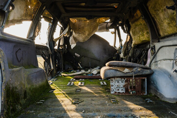 old abandoned and rusty car in which grass has grown